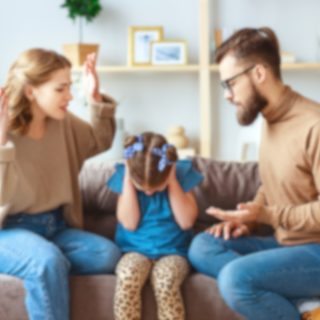 Streitende Eltern auf einer Couch, dazwischen ein Kind, das sich die Ohren zuhält.