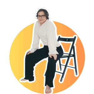 Inga mit weissem Oberteil und svchwarzer Hose auf schwarzem Klappstuhl vor orangenem Hintergrund